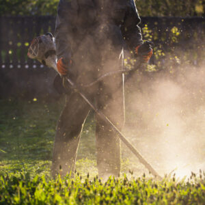 Mowing the grass with a lawn mower. Garden work concept background.